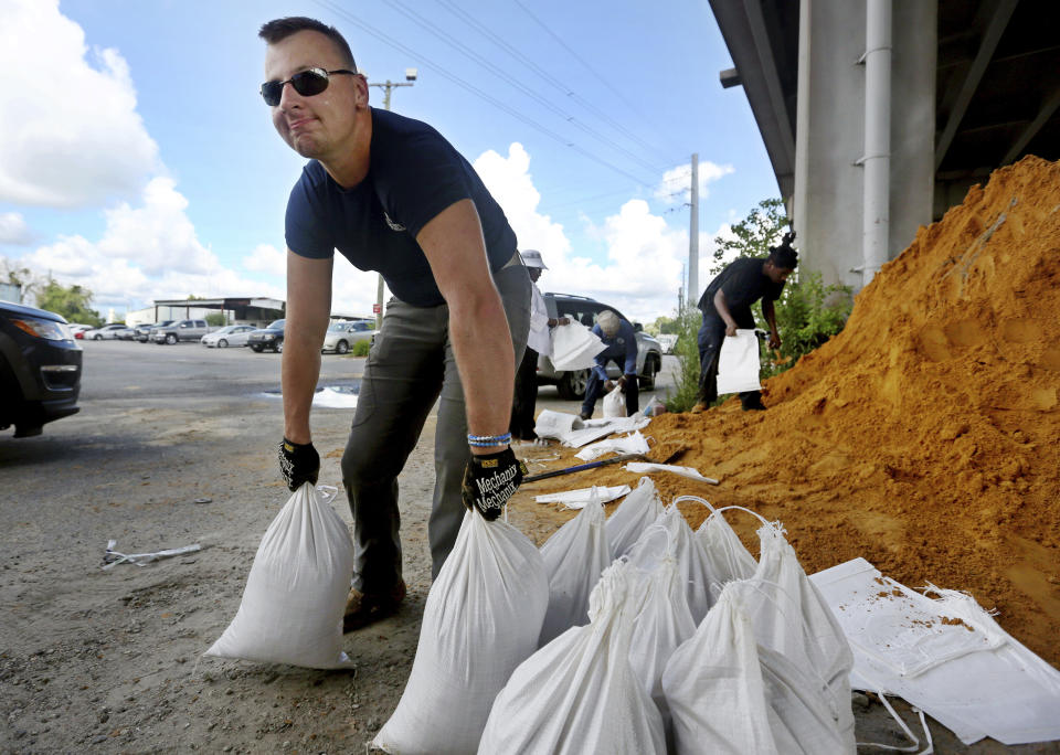 Kevin Orth loads sandbags into cars on Milford Street as he helps residents prepare for Hurricane Florence, Monday, Sept. 10, 2018, in Charleston, S.C. (Grace Beahm Alford/The Post And Courier via AP)