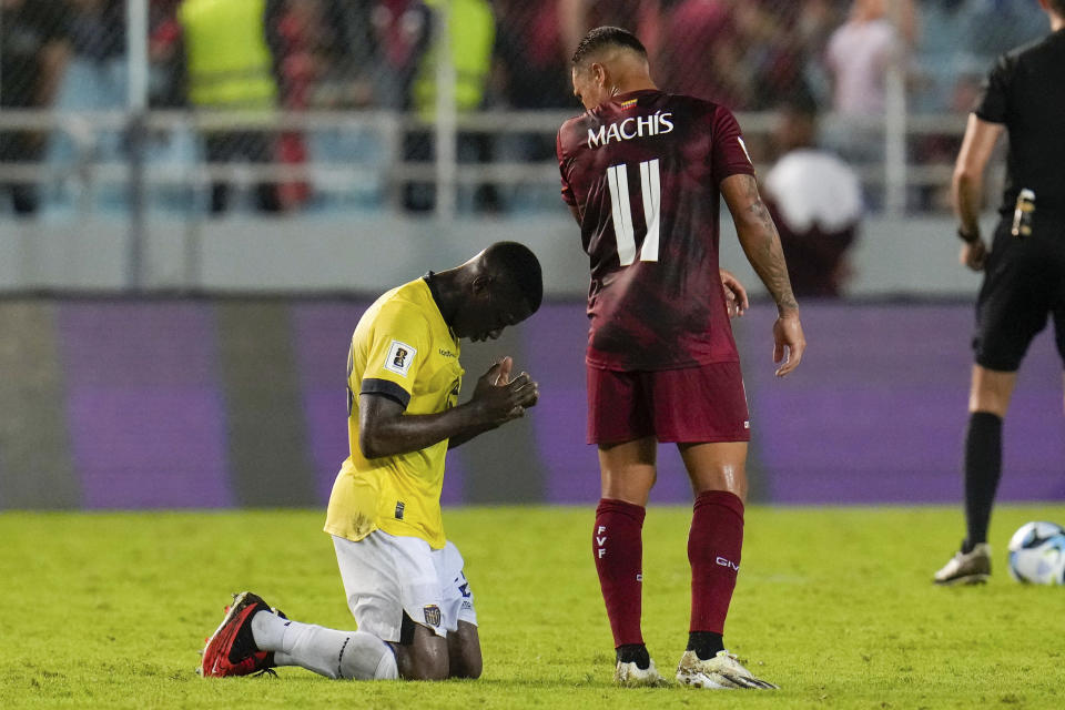 Moisés Caicedo, de la selección de Ecuador, se arrodilla junto a Darwin Machis, de Venezuela, tras un partido de la eliminatoria mundialista, realizado el jueves 16 de noviembre de 2023 (AP Foto/Ariana Cubillos)