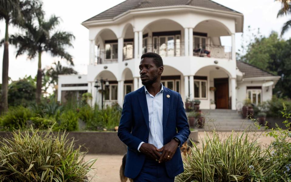 Bobi Wine stands outside his home as security forces surround his property on January 15 - Getty Images