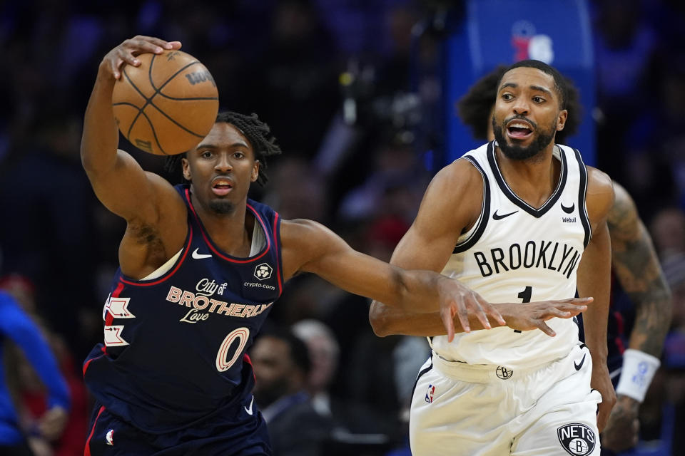 Philadelphia 76ers' Tyrese Maxey, left, and Brooklyn Nets' Mikal Bridges chase a loose ball during the first half of an NBA basketball game, Saturday, Feb. 3, 2024, in Philadelphia. (AP Photo/Matt Slocum)