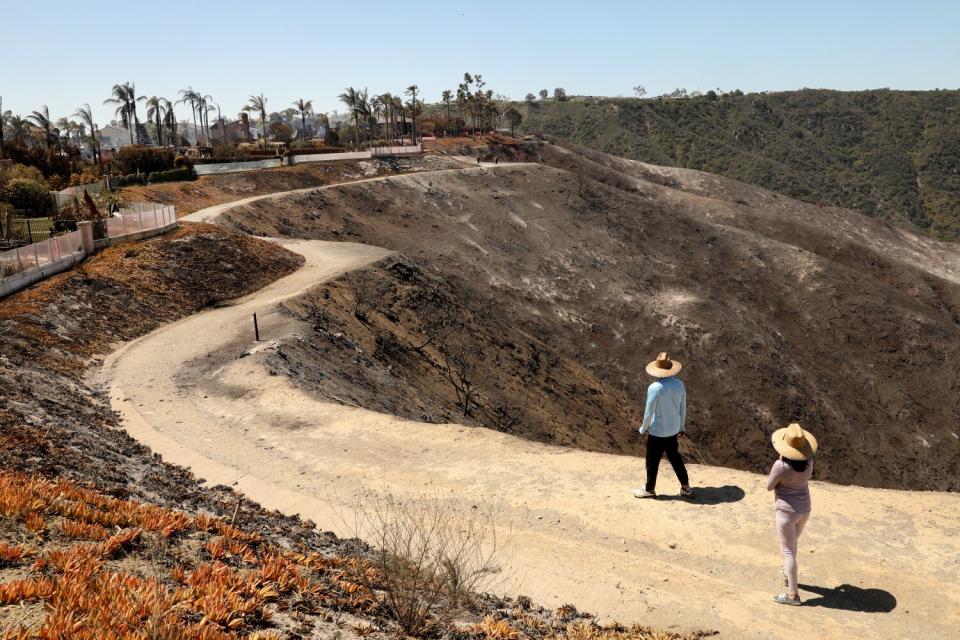 People walk along a path behind the homes on Coronado Pointe.