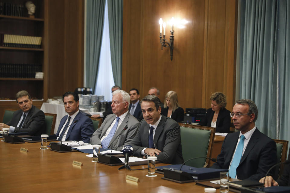 Greek Prime Ministers Kyriakos Mitsotakis, second right, speaks next to Finance Minister Christos Staikouras, right, as the new government participate in their first cabinet meeting, in Athens, Wednesday, July 10, 2019. Conservative party leader Kyriakos Mitsotakis won Sunday's election on pledges that included making the country more businesses-friendly, cutting taxes and negotiating an easing of draconian budget conditions agreed as part of the country's rescue program. (AP Photo/Petros Giannakouris)