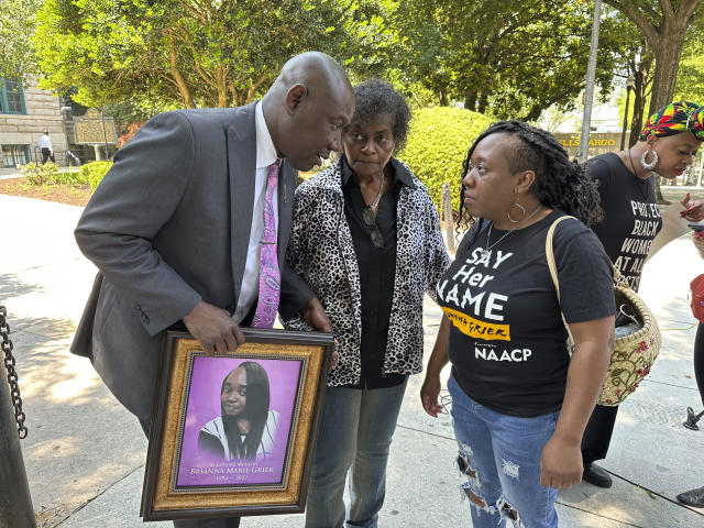 Prominent civil rights attorney Ben Crump speaks to Brianna Grier's mother Mary Grier, center, and sister Lottie Grier, right, following a news conference announcing a wrongful death lawsuit, in Decatur, Ga., Wednesday, May 24, 2023. The lawsuit accuses Hancock County Sheriff's deputies of improperly arresting Brianna Grier and ultimately causing her death, after she fell out of a moving patrol car following her arrest in July 2022. (AP Photo/Kate Brumback)