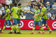 Seattle Sounders midfielder Cristian Roldan celebrates with teammates after scoring during the first half of an MLS soccer match against Sporting Kansas City, Sunday, Sept. 26, 2021, in Kansas City, Kan. (AP Photo/Nick Tre. Smith)