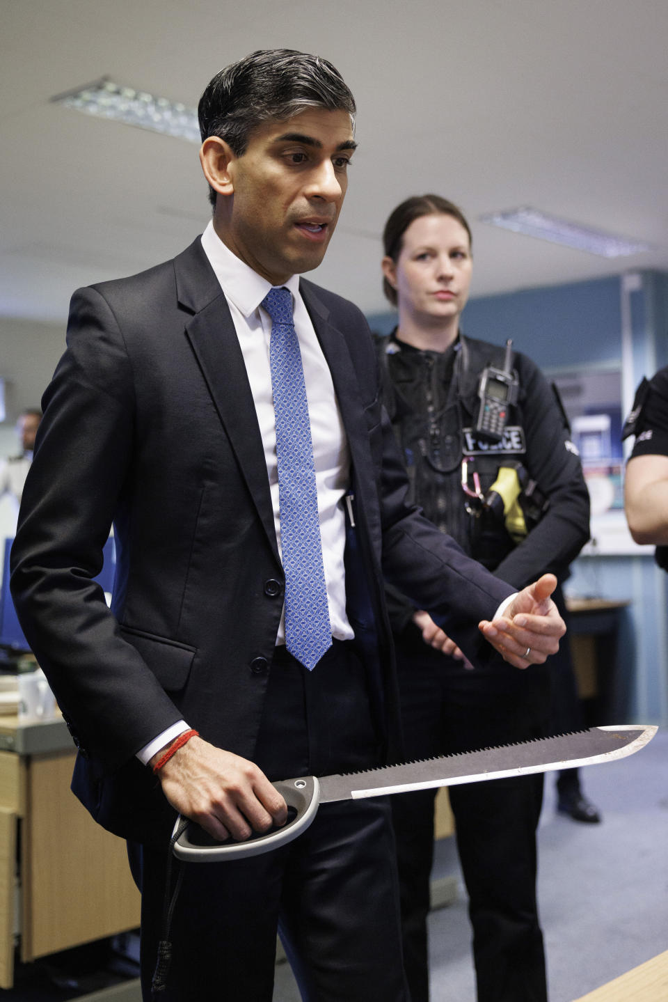 FILE - Britain's Prime Minister Rishi Sunak picks up a machete while visiting Harlow Police Station during a media visit in Essex, England, Friday Feb. 16, 2024. Knife crimes are on the rise in England and Wales, and a string of deadly attacks in recent years has stoked public anxiety and led to calls for the government to do more. (Dan Kitwood/Pool Photo via AP, File)