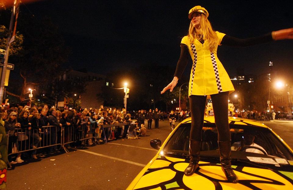 A participant rides on top of a taxi while celebrating in the annual Village Halloween Parade, Oct. 31, 2007, in New York City. Approximately 2 million visitors attend the event each year, making it the largest Halloween celebration in the country.