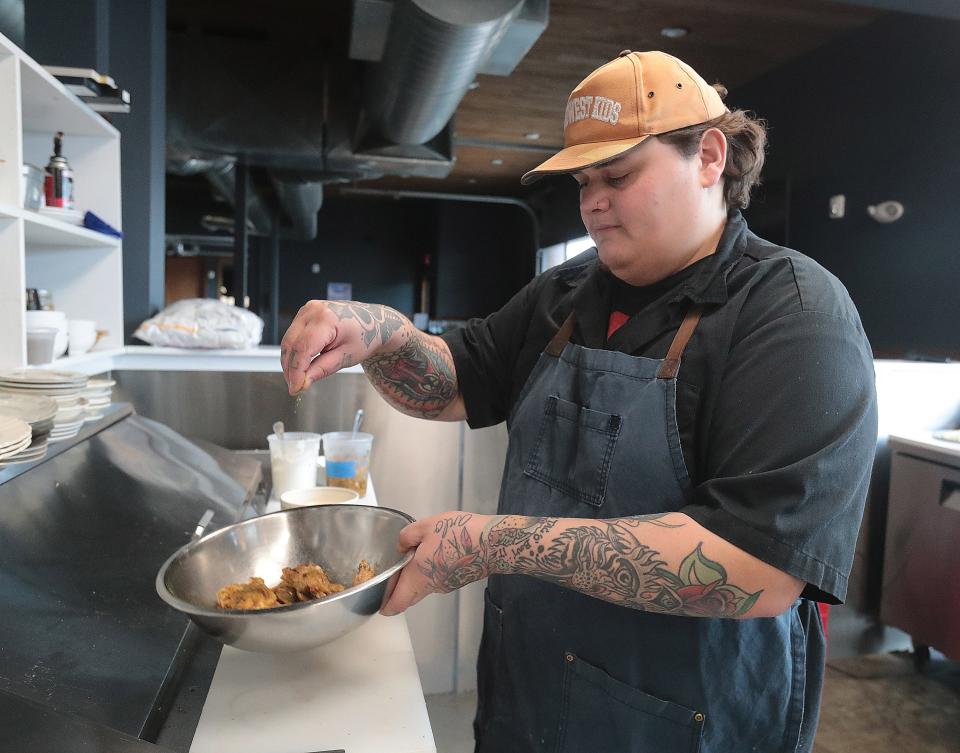 Alejandro Najar of Barberton, head chef at UnHitched Brewing Co. in Louisville, adds za'atar seasoning to his za'atar chicken wings.