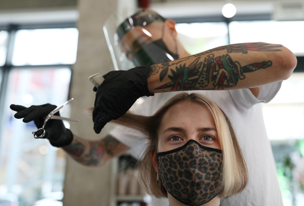 Pont Smith, co-owner and stylist of bebop hair salon in London, wears PPE as he cuts the hair of model Daisy George, during final preparations ahead of the salon's reopening, as further coronavirus lockdown restrictions are lifted in England. (Photo by Yui Mok/PA Images via Getty Images)