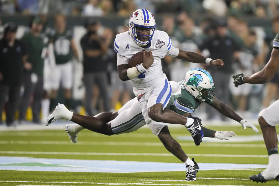 SMU quarterback Kevin Jennings carries past Tulane safety Bailey Despanie during the second half of the American Athletic Conference championship NCAA college football game, Saturday, Dec. 2, 2023 in New Orleans. SMU won 26-14. (AP Photo/Gerald Herbert)