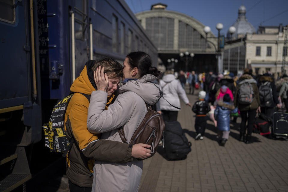 A mother embraces her son who escaped the besieged city of Mariupol and arrived at the train station in Lviv, western Ukraine on Sunday, March 20, 2022. (AP Photo/Bernat Armangue)