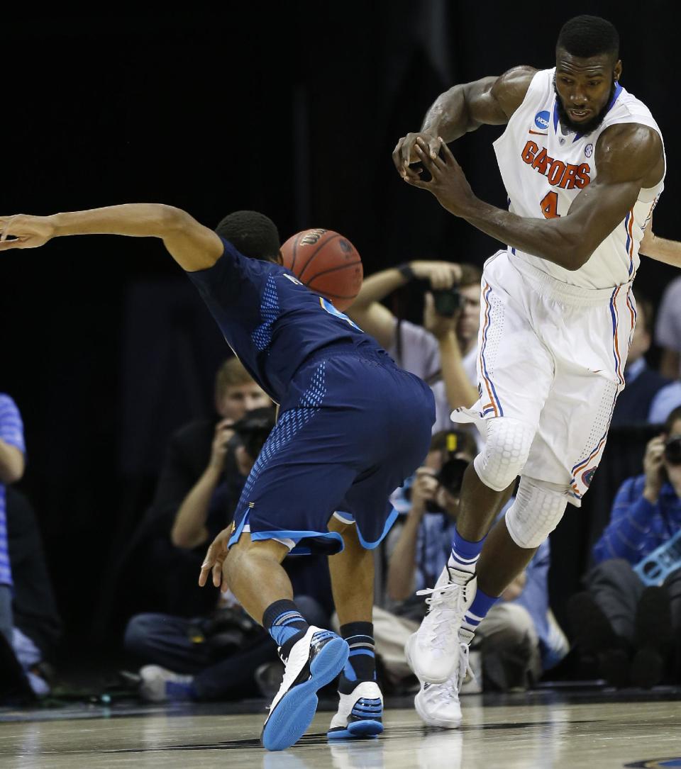 Florida center Patric Young (4) collides with UCLA guard Norman Powell (4) during the first half in a regional semifinal game at the NCAA college basketball tournament, Thursday, March 27, 2014, in Memphis, Tenn. (AP Photo/John Bazemore)