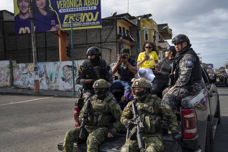 Soldiers patrol from on top of an armored vehicle as supporters of presidential candidate Daniel Noboa, of the National Democratic Action Alliance political party, attend a rally downtown in Esmeraldas, Ecuador, Friday, Oct. 6, 2023. Ecuador will hold a presidential runoff, Oct. 15. (AP Photo/Rodrigo Abd)