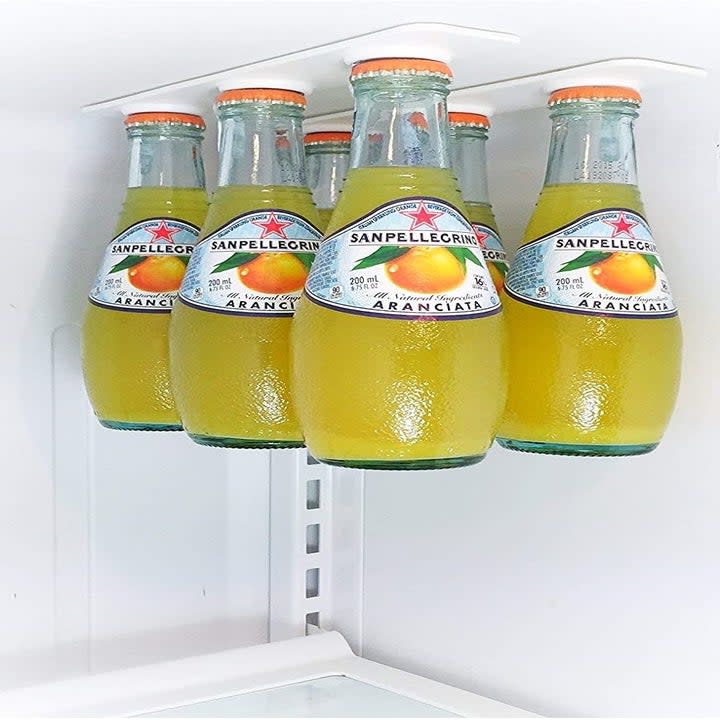 glass bottles of juice hanging from the bottle hangers 