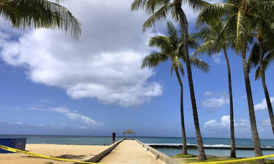 A man walks along a closed pier on Waikiki Beach in Honolulu in late March.