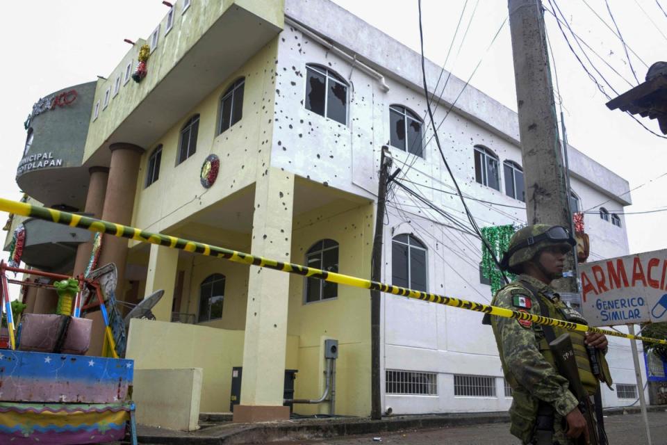 A member of the Mexican Army stands guard in front of the bullet-ridden building of the Municipality of San Miguel Totolapan, state of Guerrero, Mexico, on October 2022 (AFP via Getty Images)