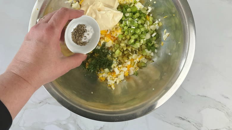 adding salt and pepper to egg salad