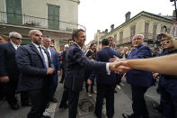 French President Emmanuel Macron greets the crowd as he arrives at Jackson Square in New Orleans, Friday, Dec. 2, 2022. Right is former New Orleans Mayor Mitch Landrieu. (AP Photo/Gerald Herbert)