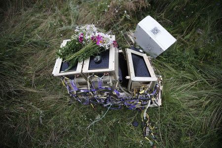 Flowers lie on debris from a Malaysian Airlines Boeing 777 plane which was downed on Thursday near the village of Rozsypne, in the Donetsk region July 18, 2014. REUTERS/Maxim Zmeyev