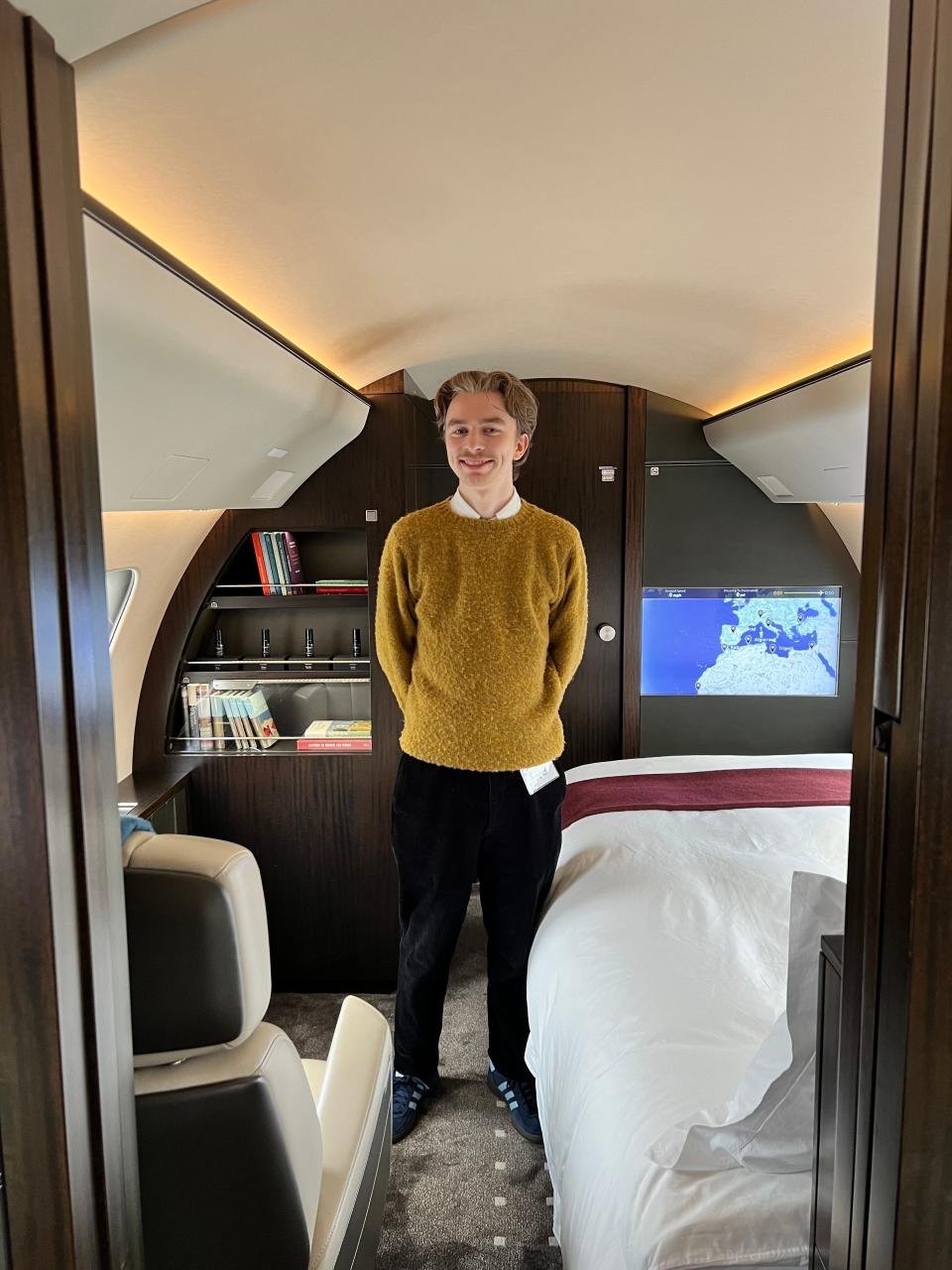 Business Insider's Pete Syme stands in the bedroom of a VistaJet Bombardier Global 7500