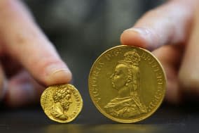 File photo dated 21/01/14 of Rachel Morgan, Auction Administrator at Bellmans Auctioneers in Wisborough Green, West Sussex, holding (left) a Roman Empire, Marcus Aurelius as Augustus dated AD 161-180 and a Victoria (right), gold Five Pounds, Jubilee head dated 1887, coins which feature in a coin collection which is due to be auctioned. PRESS ASSOCIATION Photo. Issue date: Friday January 24, 2014. The coins have been passed down through the generations of a Sussex family for more than a century. See PA story SALE Coins. Photo credit should read: Gareth Fuller/PA Wire