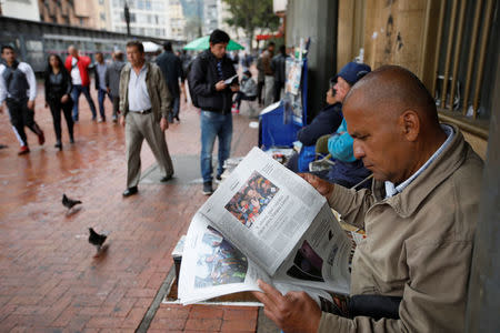 A man reads a newspaper that shows candidates Gustavo Petro and Ivan Duque go to the second round of presidential election, in Bogota, Colombia May 28, 2018. REUTERS/Jaime Saldarriaga