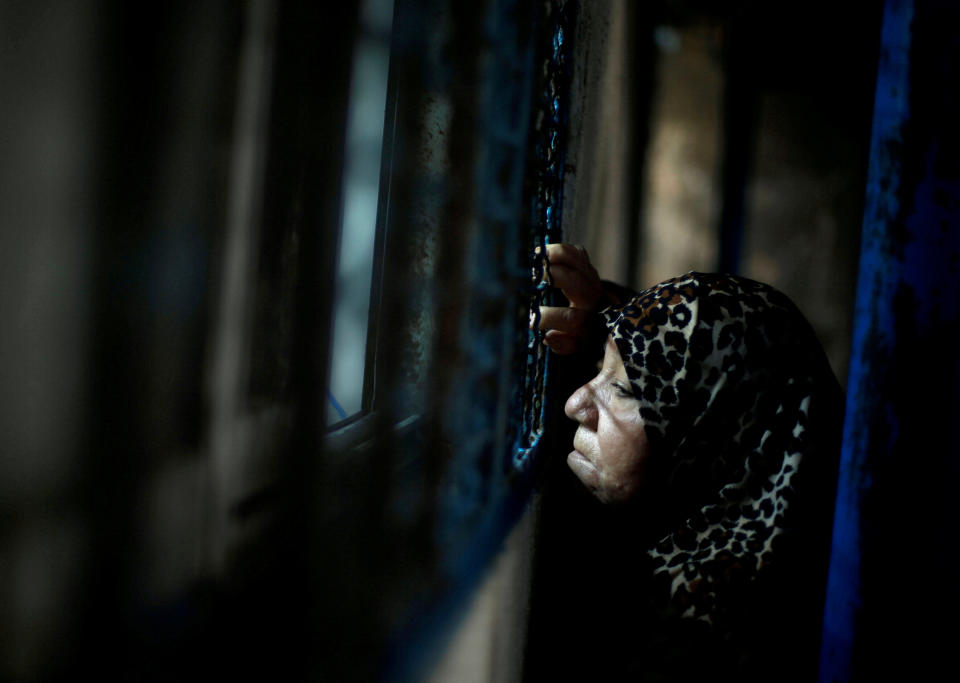 FILE PHOTO: A Palestinian refugee woman waits to receive food supplies from a United Nations food distribution center in Al-Shati refugee camp in Gaza City December 6, 2017. REUTERS/Mohammed Salem/File Photo