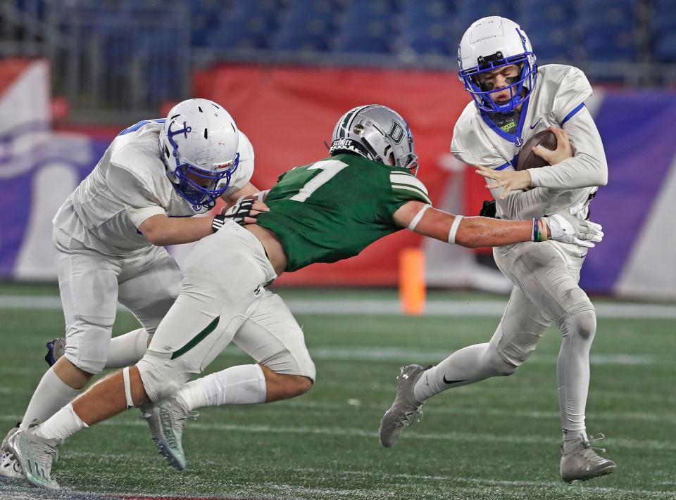Scituate QB Jackson Belsan avoids a sack by Dragon Finn Carley. Duxbury High and Scituate High play the MIAA Division 4 State Championship at Gillette Stadium on Friday, Dec. 1, 2023.