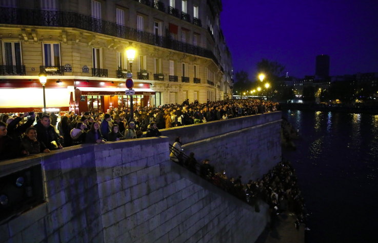 Thousands watch from the banks of the Seine. Source: AP