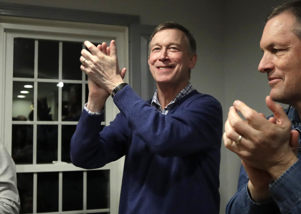 FILE - In this Feb. 13, 2019, file photo, former Colorado Gov. John Hickenlooper, left, applauds at a campaign house party in Manchester, N.H. While the Democratic primary field has shifted left, polls show registered Democratic voters just want someone who can beat Donald Trump. That’s led to a potential contradiction being worked over by primary voters. Is the best route to victory to build a liberal movement to win converts or choose a more moderate candidate who can appeal to swing voters? (AP Photo/Elise Amendola, File)