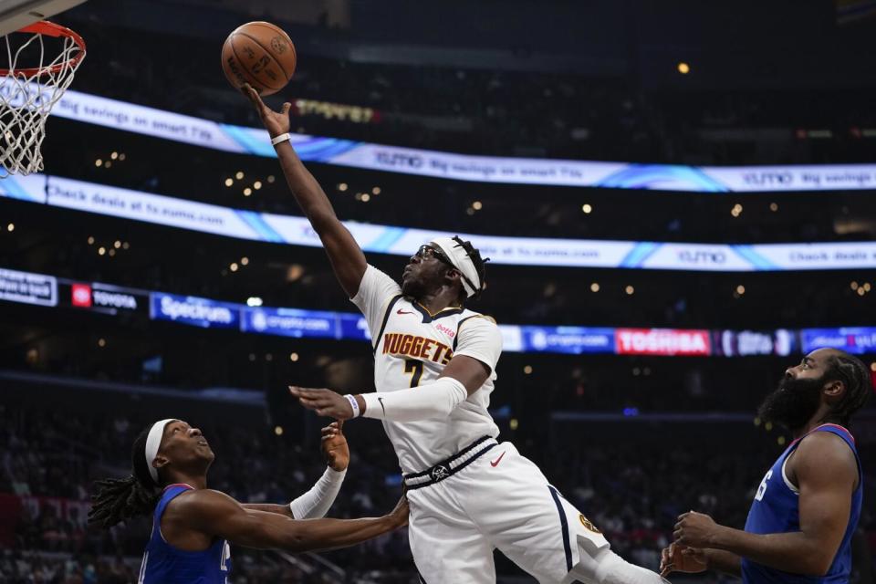 Denver Nuggets guard Reggie Jackson shoots over Clippers guards Terance Mann and James Harden.