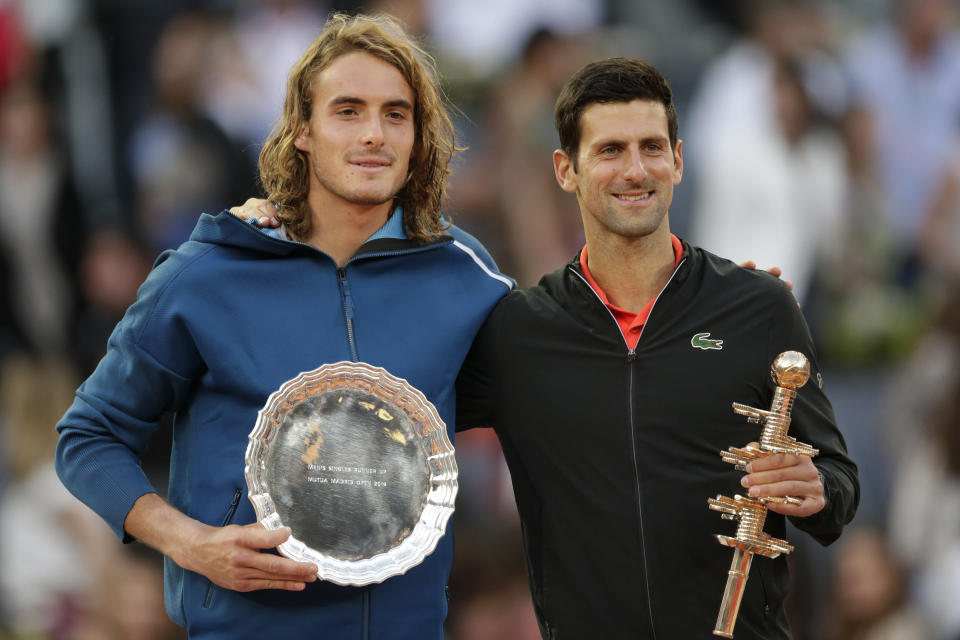 Serbia's Novak Djokovic, right, holds the trophy as he celebrates winning the final of the Madrid Open tennis tournament in two sets, 6-3, 6-4, against Greece's Stefanos Tsitsipas, left, in Madrid, Spain, Sunday, May 12, 2019. (AP Photo/Bernat Armangue)
