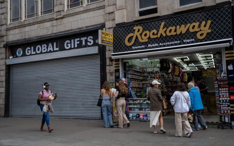 People pause outside a souvenir shop on Oxford Street