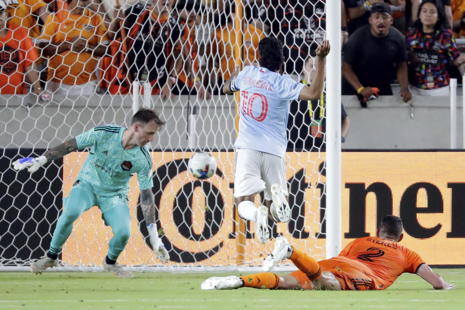 FC Dallas forward Jesus Ferreira (10) jumps over Houston Dynamo defender Daniel Steres (2) as his goal kick gets past goalkeeper Steve Clark, left, during the second half of an MLS soccer match Saturday, July 9, 2022, in Houston. (AP Photo/Michael Wyke)