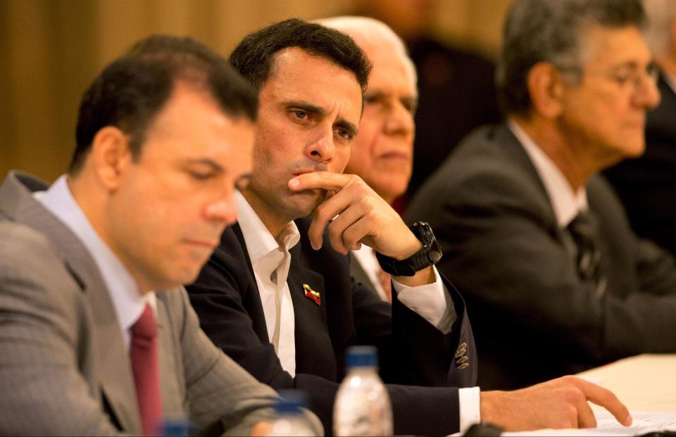 Opposition leader Enrique Capriles listens to Aldo Giordano, the Vatican's representative in Venezuela, during a meeting between the opposition and the government at Miraflores presidential palace in Caracas, Venezuela, Thursday, April 10, 2014. The Vatican is sponsoring the first talks aimed at reconciliation since protests began in early February. The negotiations are marked by widespread mistrust on both sides. (AP Photo/Fernando Llano)