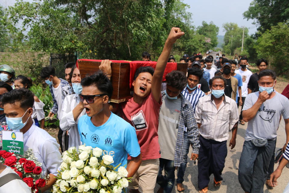 In this April 1, 2021 photo provided by Dawei Watch news outlet, a man raises his hand with a clenched fist as he carries the coffin of 17-year old Kyaw Min Latt during a funeral procession in Dawei, Myanmar. Since the military seized control of Myanmar in a takeover on Feb. 1, more than 825 people have been killed _ well over two times the official tally _ according to watchdog group Assistance Association for Political Prisoners. (Dawei Watch via AP)