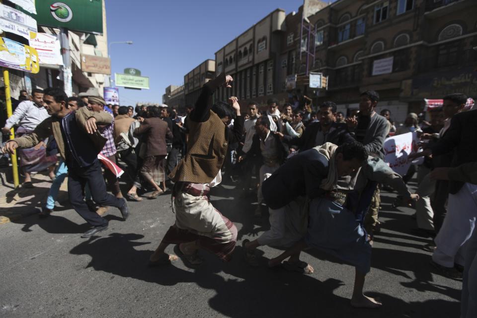 Supporters of the Houthi movement clash with anti-Houthi protesters during a rally in Sanaa