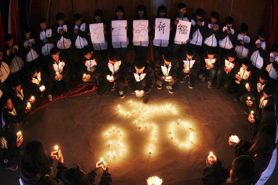 Middle school students hold candles as they pray for passengers aboard Malaysia Airline MH370 at campus in Lianyungang