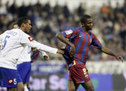 FILE - Zaragoza player Alvaro Maior De Aquino of Brazil, left tries to stop Barcelona's Samuel Eto'o of Cameroon, right, from leaving the field after racist taunts against him during a Spanish league soccer match against Zaragoza, in Zaragoza, Spain, Saturday Feb. 25, 2006. The manifestation of a deeper societal problem, racism is a decades-old issue in soccer — predominantly in Europe but seen all around the world — that has been amplified by the reach of social media and a growing willingness for people to call it out. (AP Photo/Manu Fernandez, File)