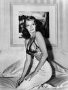 Pendant des années, Rita Hayworth est victime du harcèlement sexuel et de la jalousie maladive du producteur Harry Cohn. Ce dernier n’aurait pas supporté les supposées liaisons entre sa muse et le milliardaire Howard Hughes ou le gangster Mickey Cohen. Le nabab va même jusqu’à truffer la loge de la comédienne de micros. En parallèle, celle-ci consolide son statut de star grâce à des films comme <em>La Blonde framboise </em>(1941) et <em>Arènes sanglantes </em>(1941). Pour ce long-métrage dans lequel elle démontre à nouveau ses talents de danseuse, elle fait connaissance avec le chorégraphe Hermes Pan, qui restera l’un de ses meilleurs amis et déclarera à son sujet : "<em>Les gens l’identifiaient à la fascinante déesse de l’amour, mais elle n’était qu’une petite fille de huit ans. </em>[…]<em> Elle m’a toujours fait penser à une gitane par sa façon de se comporter. Soudain elle se levait et se mettait à danser. On lui parlait, mais elle ne répondait pas, elle se contentait de danser. Et c’était beau !</em>". L’année 1941 est celle où Rita Hayworth s’impose comme un sex-symbol auprès du public, notamment grâce au magazine <em>Life</em>. Face à l’objectif du photographe Bob Landry, elle pose en déshabillé de satin et dentelle sur son lit. Un cliché qui n’échappe pas à un certain Orson Welles… <em>(Photo by Bob Landry/The LIFE Images Collection via Getty Images/Getty Images)</em>