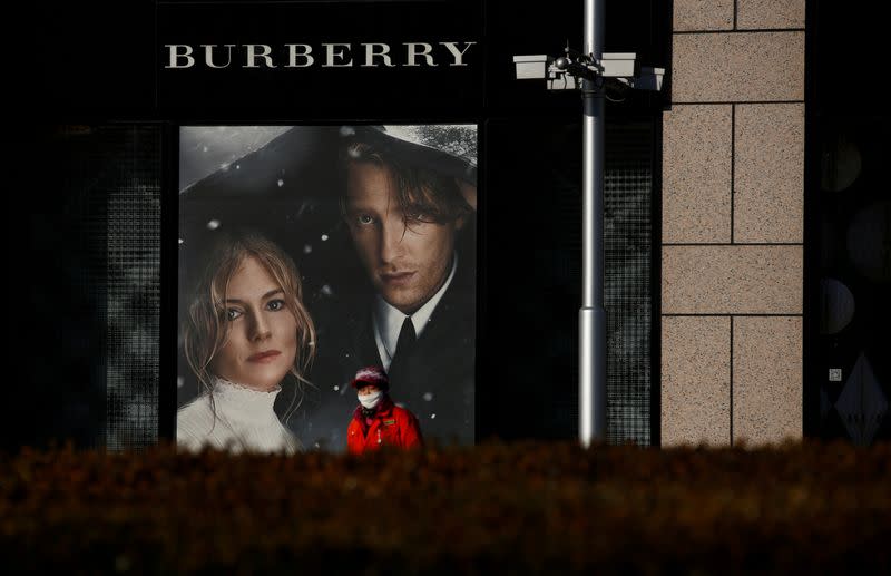 FILE PHOTO: A woman walks past a Burberry boutique in Beijing, China