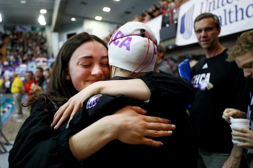 Cincinnati Hills Christian Academy’s Abigail Connor, left, hugs teammate Taylor Bacher after Bacher won the girls 200-yard freestyle during the Division II state swimming meet Friday at C.T. Branin Natatorium in Canton.