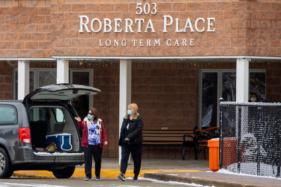 Two women wears face masks outside of Roberta Place, a long term seniors care facility which is the site of a coronavirus disease (COVID-19) outbreak, in Barrie, Ontario, Canada January 18, 2021.  REUTERS/Carlos Osorio