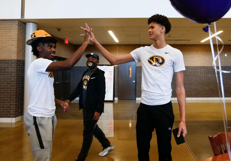 Kickapoo basketball players Trevon Brazile, right, and Anton Brookshire perform a handshake Nov. 11, when they signed with coach Cuonzo Martin and Missouri.