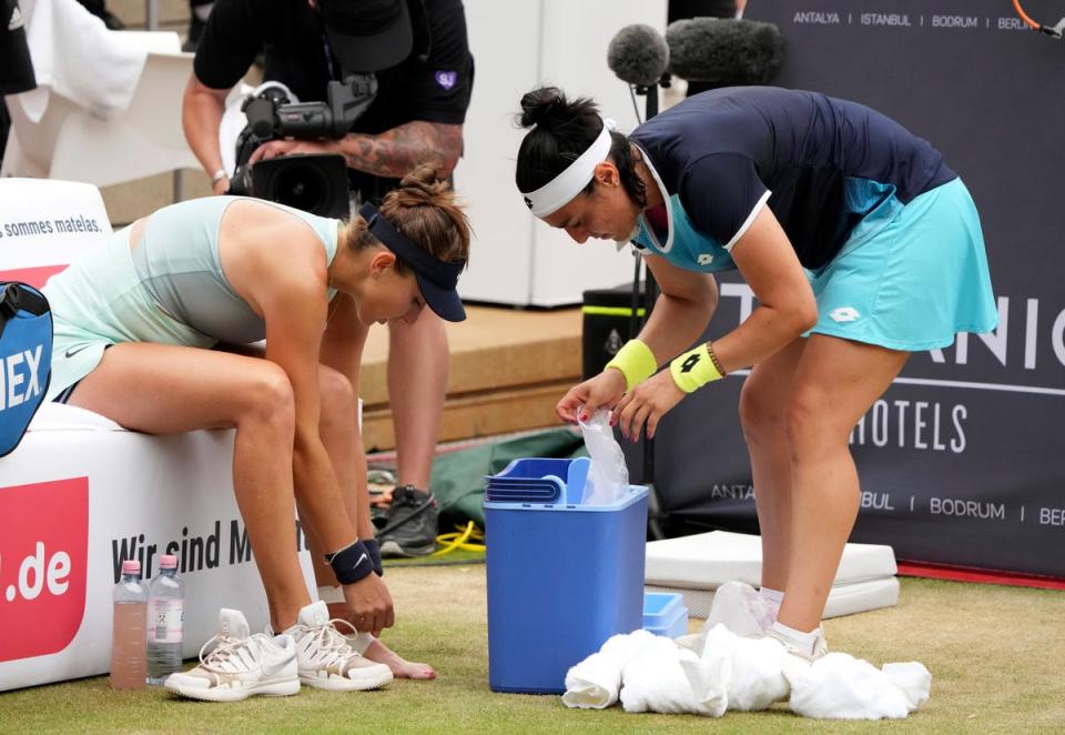 Ons Jabeur, right, helps opponent Belinda Bencic after she sustained an ankle injury (Michael Sohn/AP) (AP)