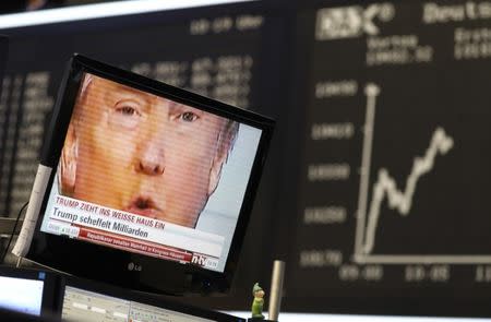 A TV screen showing U.S. President-elect Donald Trump is pictured in front of the German share price index, DAX board, at the stock exchange in Frankfurt, Germany, November 9, 2016. REUTERS/Kai Pfaffenbach