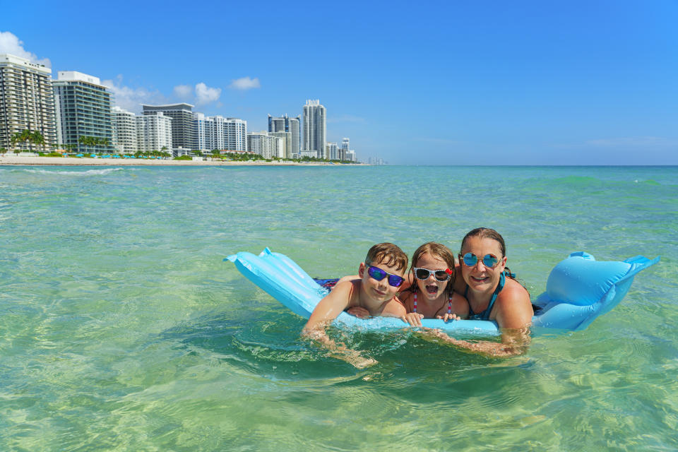 Family joy in a holiday paradise - Miami Beach. Happy moments in the clean  water. Travel myth: travel is too expensive