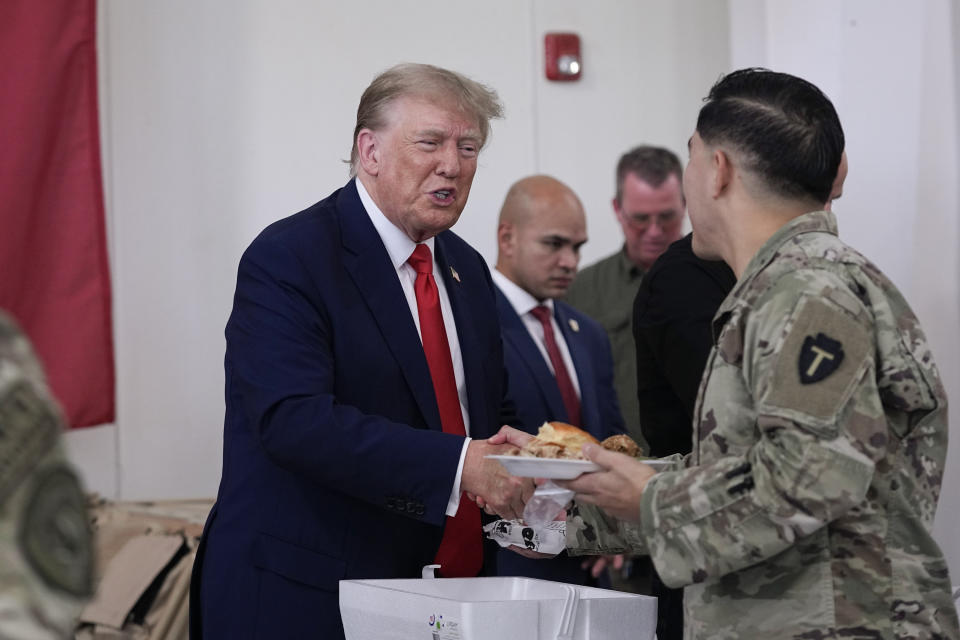 Republican presidential candidate and former President Donald Trump helps serve food to Texas National Guard soldiers, troopers and others who will be stationed at the border over Thanksgiving, Sunday, Nov. 19, 2023, in Edinburg, Texas. (AP Photo/Eric Gay)