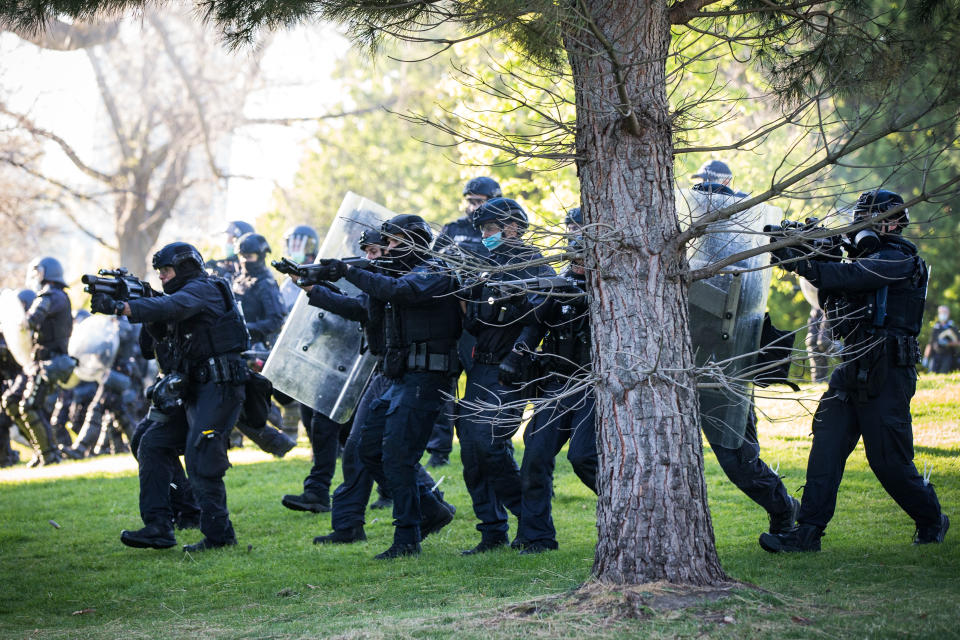 MELBOURNE, AUSTRALIA - SEPTEMBER 22: Members of the Critical Incident Response Team (CIRT) with Victoria Police move in and fire non-lethal crowd control rounds at protesters refusing to leave the Shrine of Remembrance on September 22, 2021 in Melbourne, Australia. Protests started on Monday over new COVID-19 vaccine requirements for construction workers but  turned into larger and at times violent demonstrations against lockdown restrictions in general. Melbourne is currently subject to COVID-19 lockdown restrictions, with people only permitted to leave home for essential reasons. (Photo by Darrian Traynor/Getty Images)