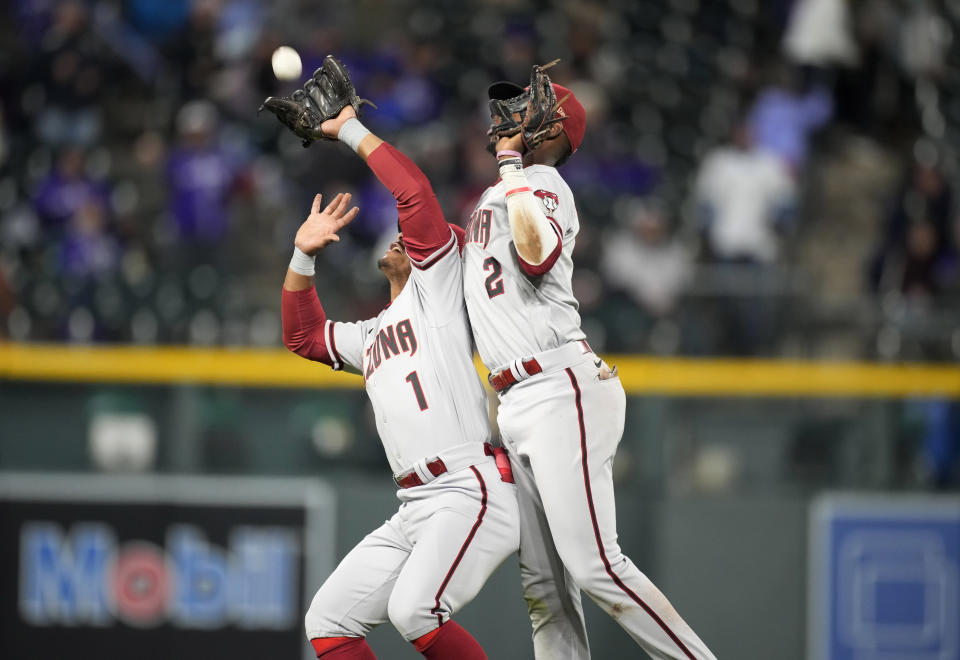 Arizona Diamondbacks shortstop Geraldo Perdomo, right, collides with second baseman Wilmer Difo on a popup by Colorado Rockies' Elias Diaz during the sixth inning of a baseball game Saturday, Sept. 10, 2022, in Denver. Difo made the catch. (AP Photo/David Zalubowski)