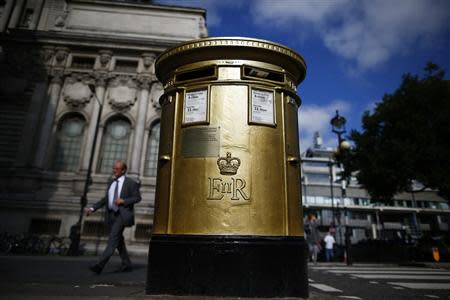 A man walks past a golden Royal Mail post box in Westminster, central London, October 8, 2013. REUTERS/Andrew Winning